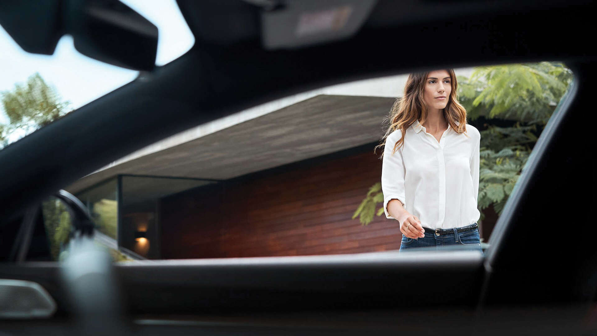 Молода жінка підходить до автомобіля Peugeot